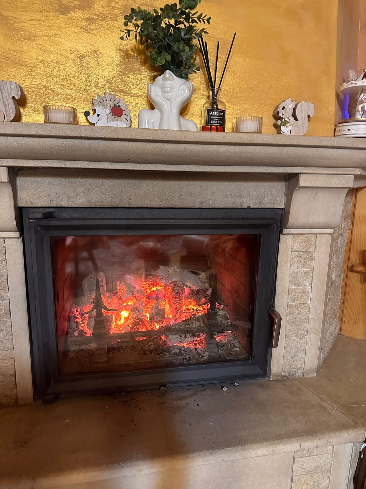 Șemineu de piatră cu lemne, pătură verde și ceaiul cald — colțul preferat